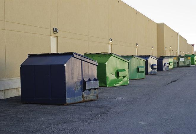 a row of yellow and blue dumpsters at a construction site in Centerton